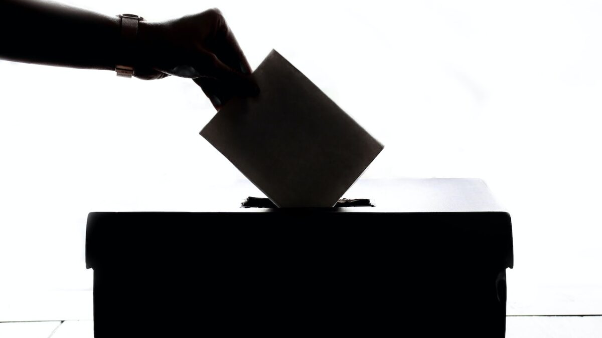 A person drops a ballot in a box